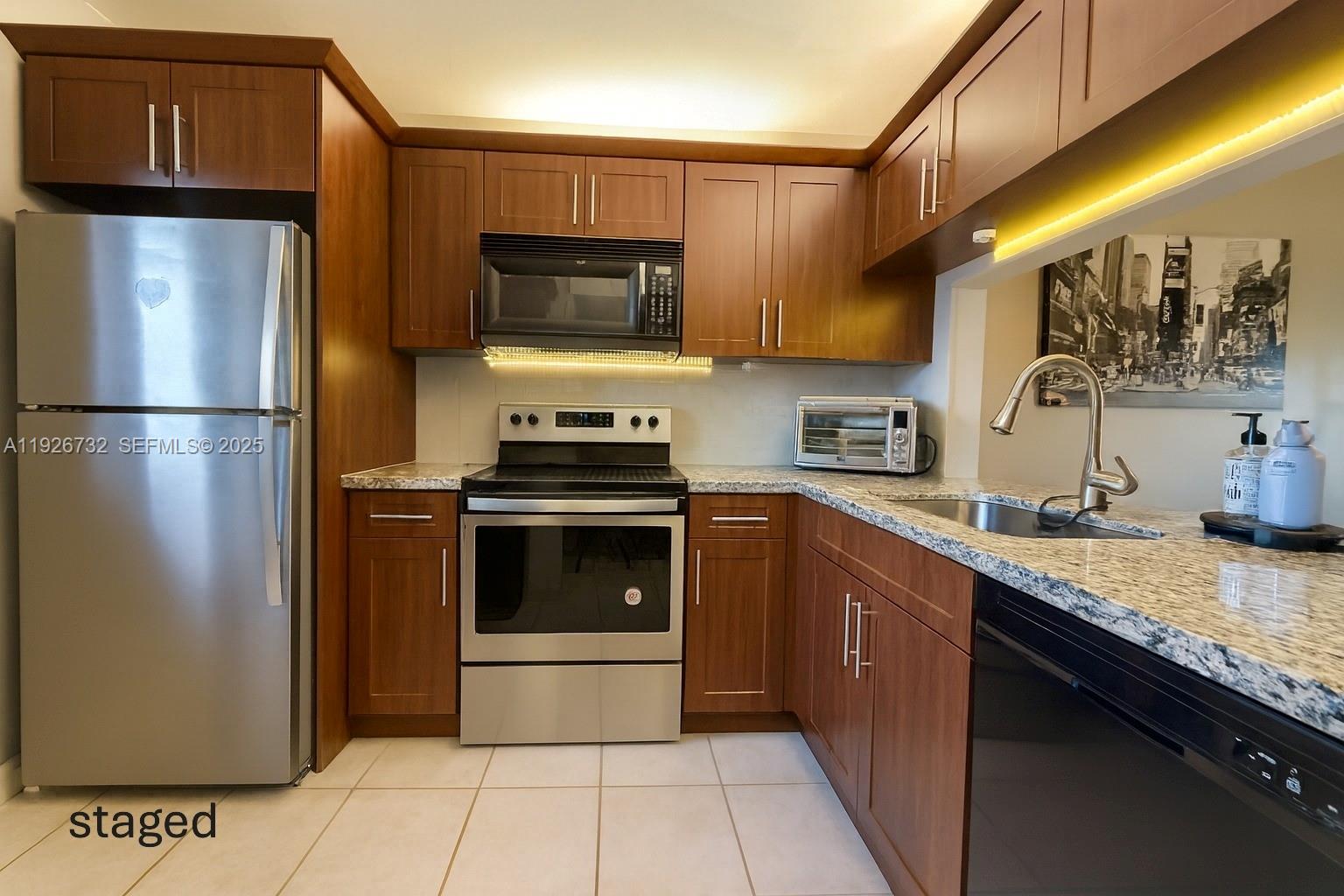 10616 Northwest 10th Street, Unit 104 Pembroke Pines, FL 33026 - Photo 2 of 47 a kitchen with stainless steel appliances granite countertop a refrigerator a stove a sink and a microwave