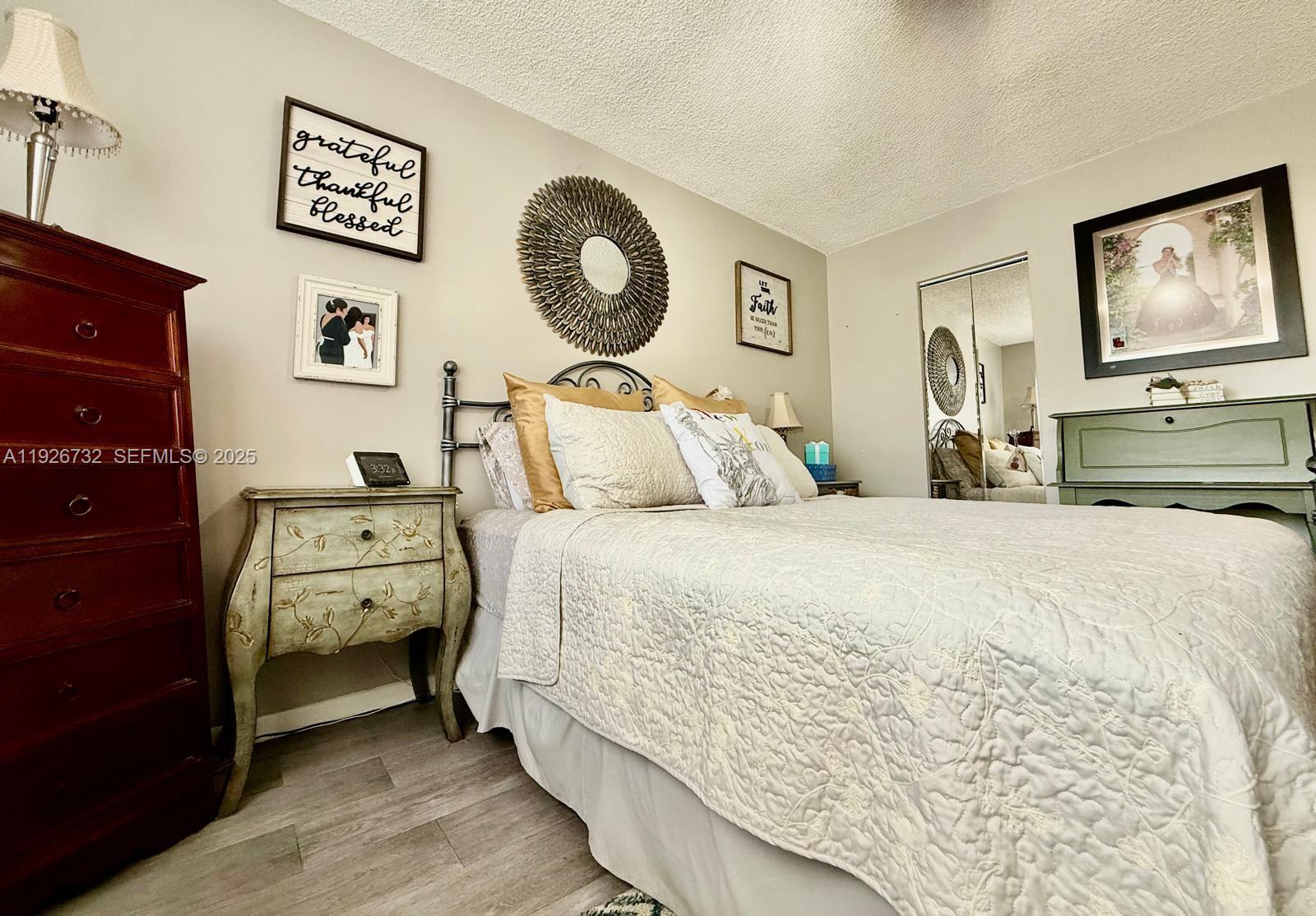 10616 Northwest 10th Street, Unit 104 Pembroke Pines, FL 33026 - Photo 23 of 47 a bedroom with a bed and a chandelier