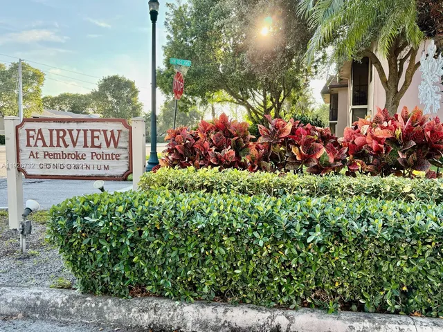 a view of a sign board with buildings in the background