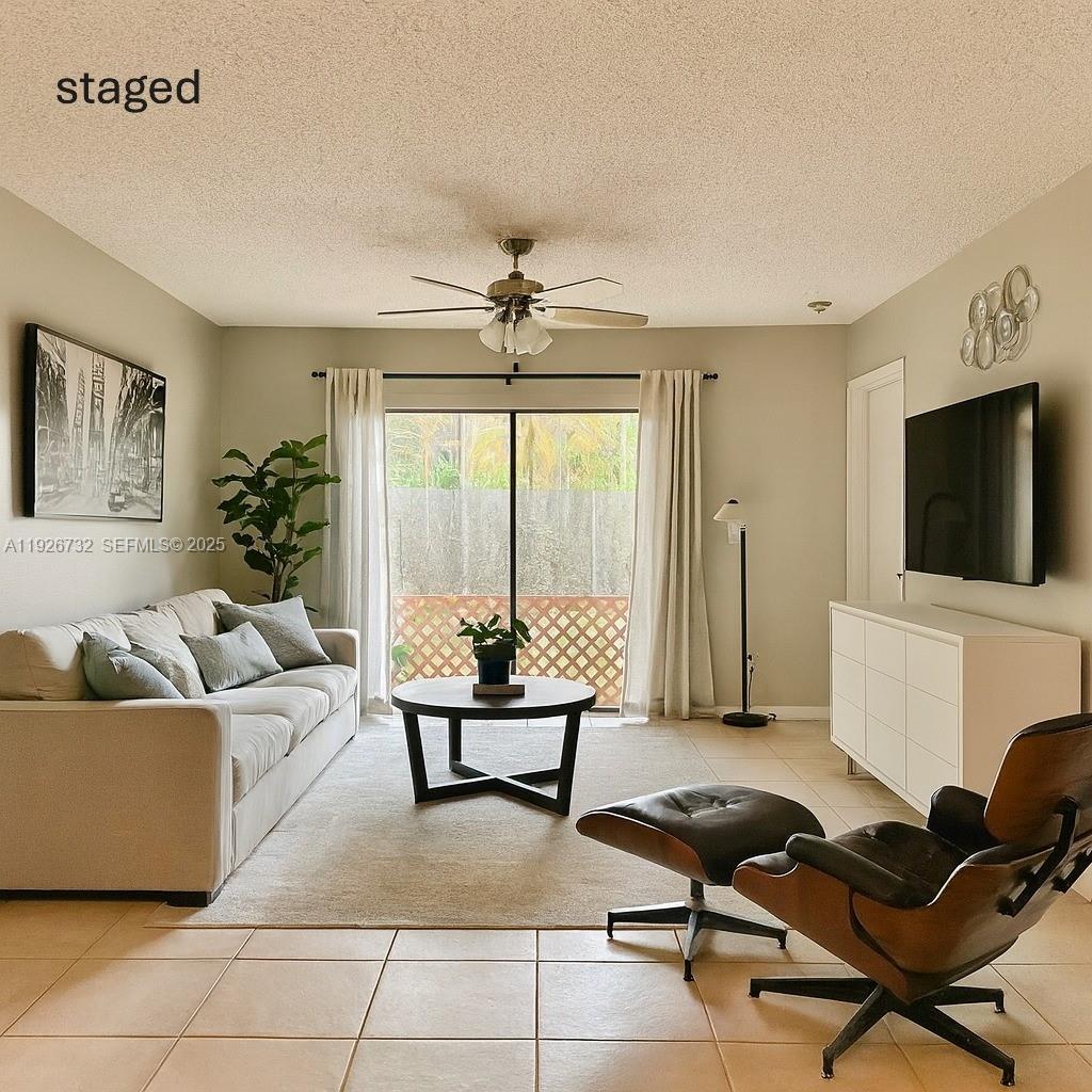 10616 Northwest 10th Street, Unit 104 Pembroke Pines, FL 33026 - Photo 7 of 47 a living room with furniture and a flat screen tv