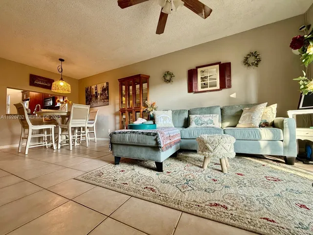 a living room with furniture and a dining table with wooden floor