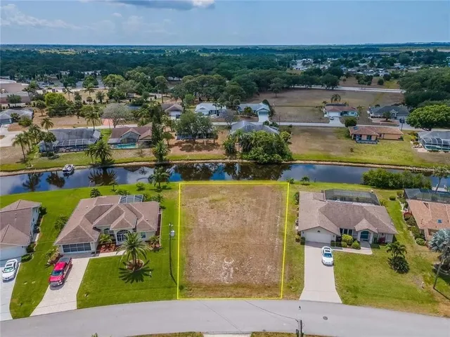 an aerial view of a house with a yard and lake view