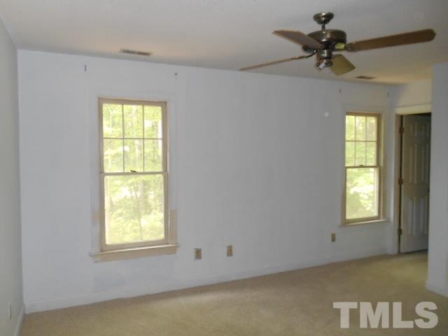 10821 Fanny Brown Road Raleigh, NC 27603 - Photo 7 of 9 an empty room with a window and a chandelier fan