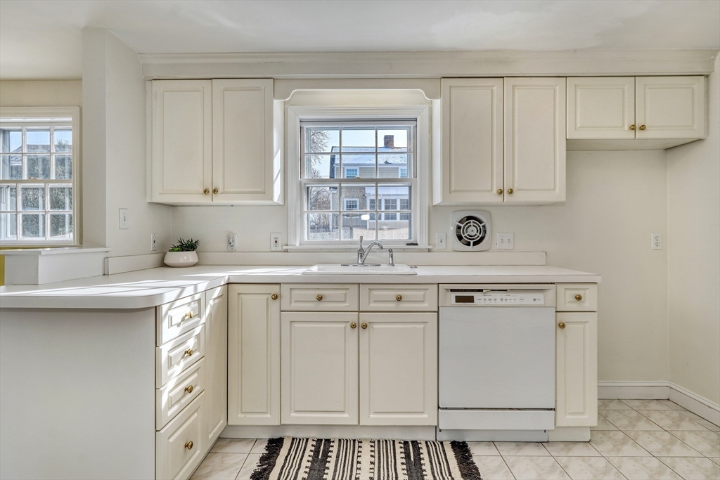 45 Bancroft Road Melrose, MA 02176 - Photo 11 of 37 a kitchen with white cabinets and white appliances