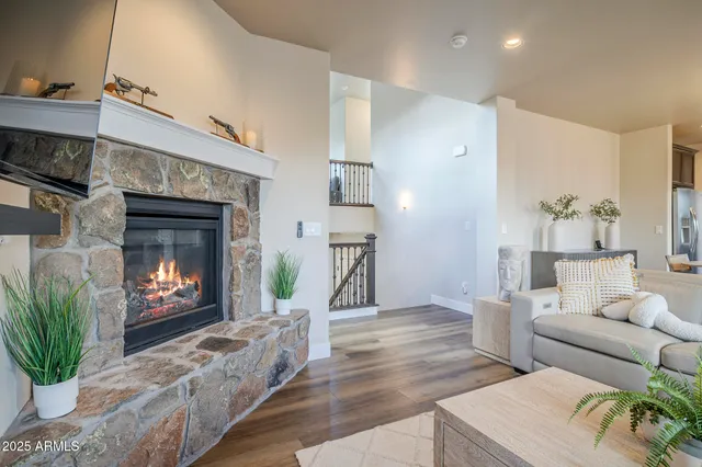a living room with furniture a flat screen tv and kitchen view