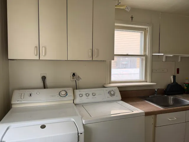 a bathroom with a sink a toilet a window and shower