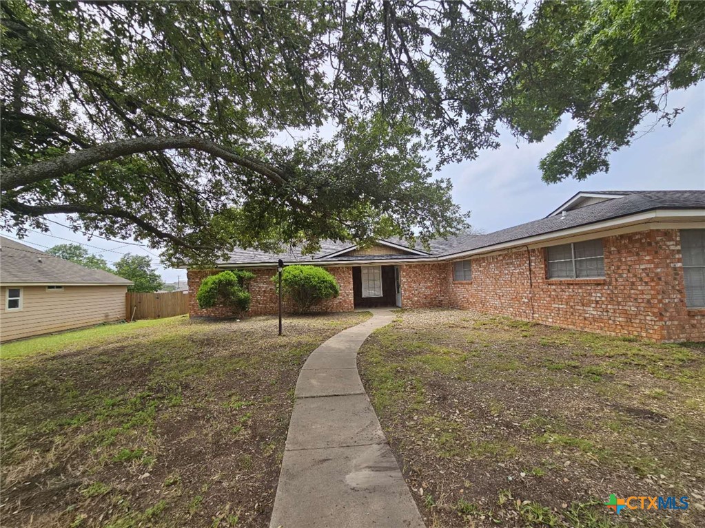 a front view of a house with yard and trees