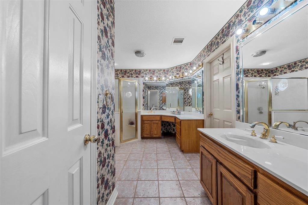 654 County Road 473 Lott, TX 76656 - Photo 15 of 40 a bathroom with a double vanity sink a mirror a bathtub and shower