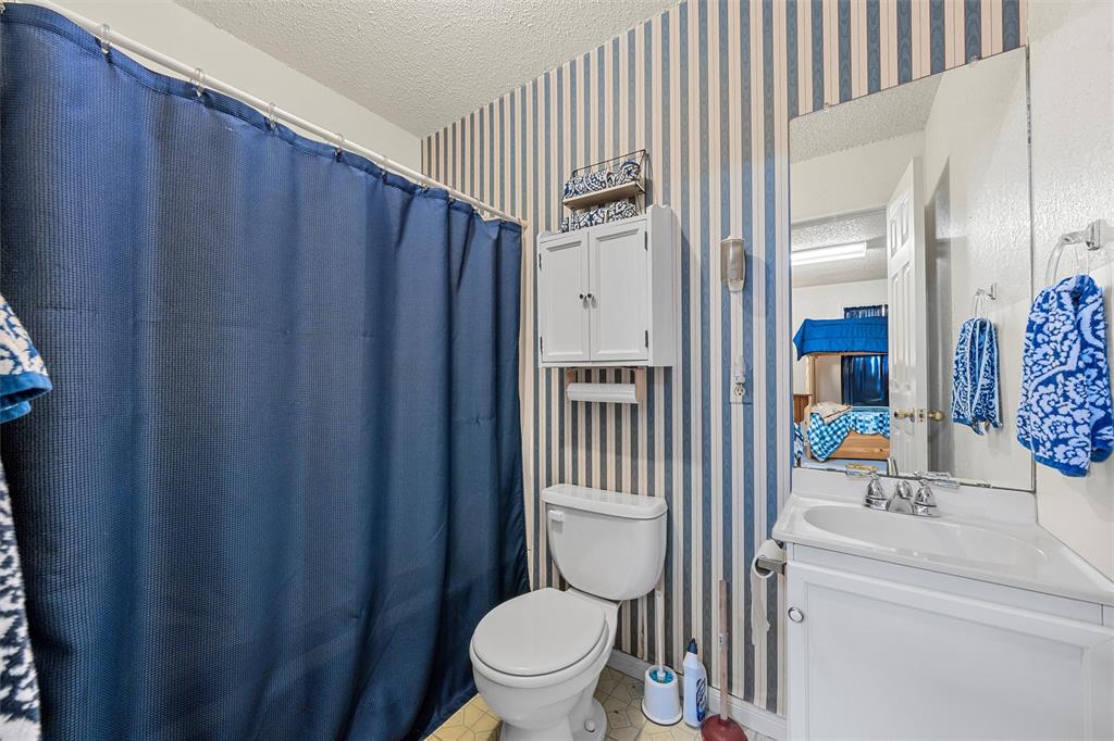 654 County Road 473 Lott, TX 76656 - Photo 19 of 40 a bathroom with a toilet a sink and curtain