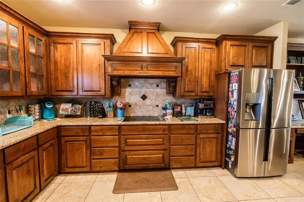 a kitchen with stainless steel appliances granite countertop a refrigerator and a sink