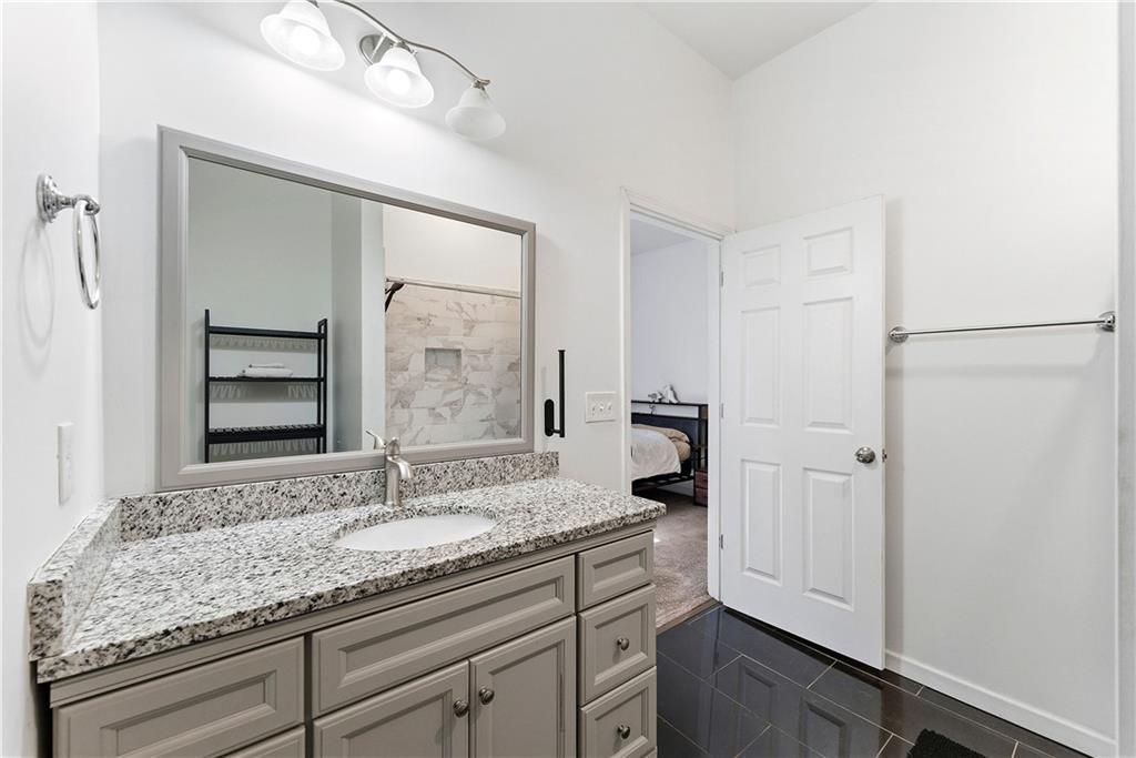 902 Gaston Street Southwest Atlanta, GA 30310 - Photo 19 of 36 a bathroom with a granite countertop sink and a mirror