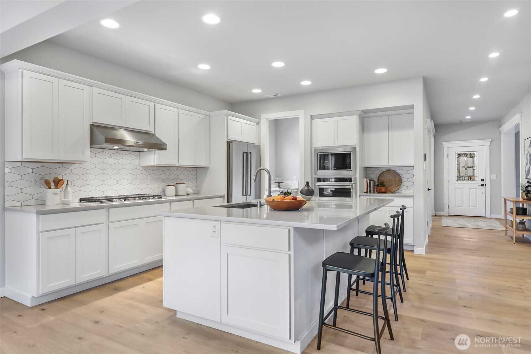 9801 Kelly Road Northeast Carnation, WA 98014 - Photo 12 of 34 a kitchen with stainless steel appliances granite countertop a stove a sink a microwave a island with a dining table and chairs