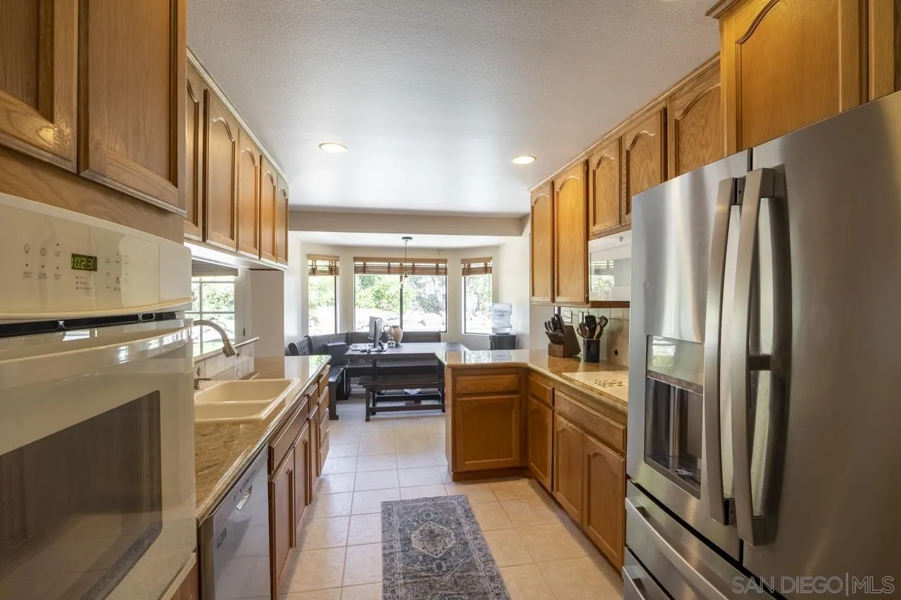 1603 Camino Del Sequan Alpine, CA 91901 - Photo 28 of 48 a kitchen with cabinets and refrigerator