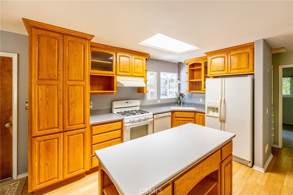 2155 Cowper Street Cambria, CA 93428 - Photo 11 of 35 a kitchen with stainless steel appliances granite countertop a refrigerator a stove and a sink with wooden floor