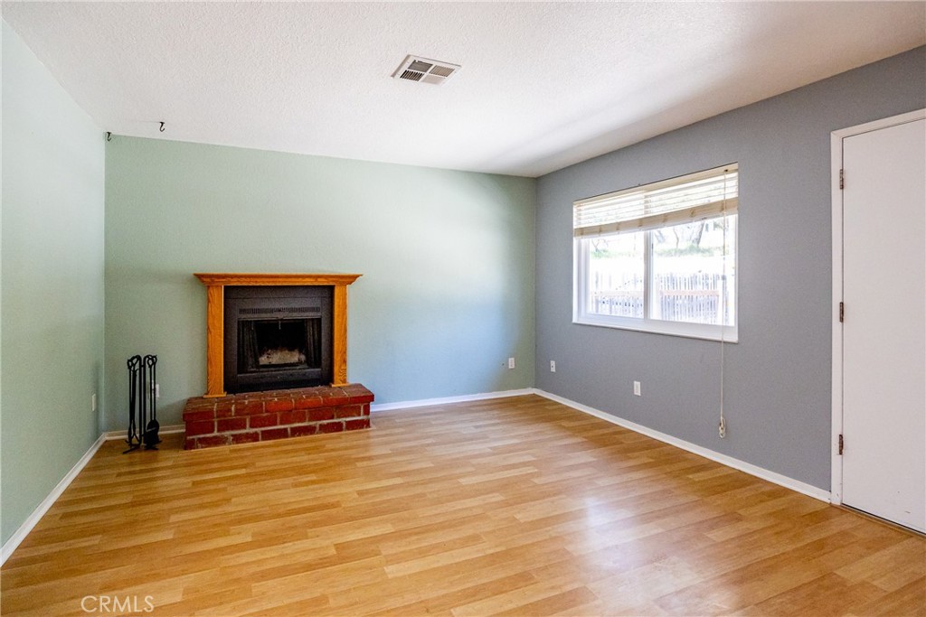 2155 Cowper Street Cambria, CA 93428 - Photo 9 of 35 a view of an empty room with wooden floor fire place and a window
