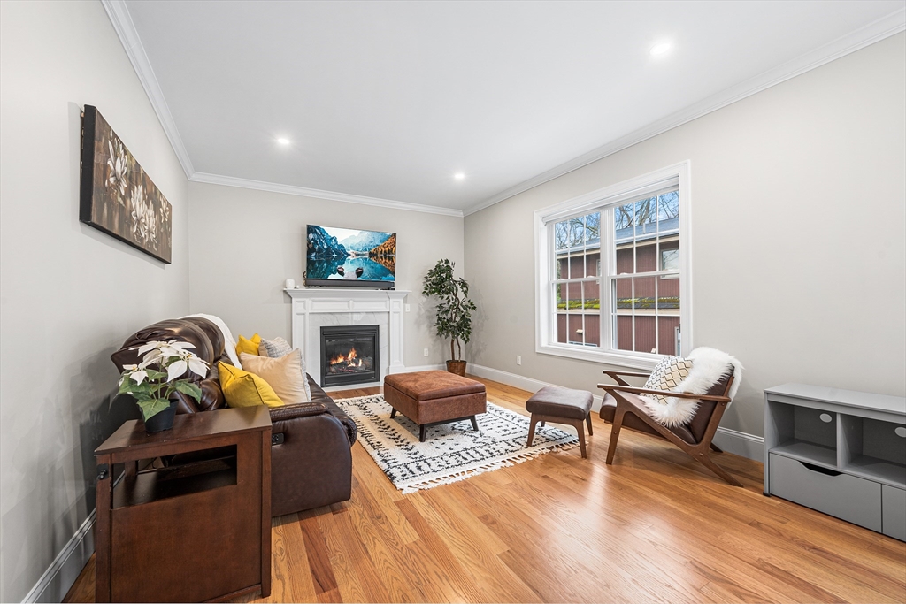32 Fraser Road Framingham, MA 01702 - Photo 7 of 37 a living room with furniture a fireplace and a floor to ceiling window