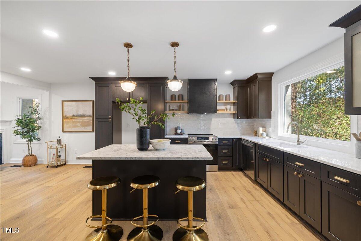 2703 Augusta Drive Durham, NC 27707 - Photo 13 of 45 a kitchen with kitchen island granite countertop a sink dining table and chairs