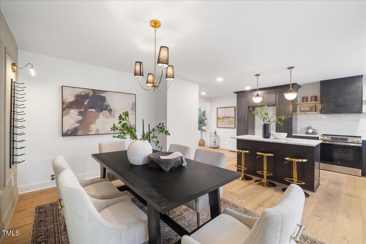 2703 Augusta Drive Durham, NC 27707 - Photo 18 of 45 a view of a dining room with furniture a kitchen and chandelier