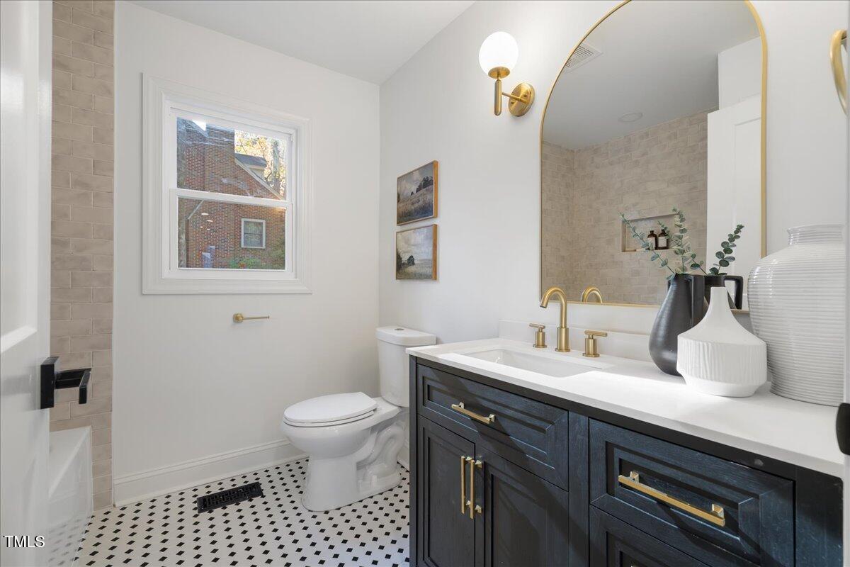 2703 Augusta Drive Durham, NC 27707 - Photo 22 of 45 a bathroom with a sink a toilet and a mirror