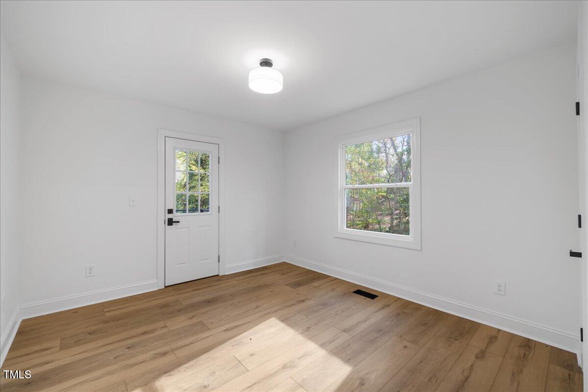 2703 Augusta Drive Durham, NC 27707 - Photo 25 of 45 an empty room with wooden floor and windows