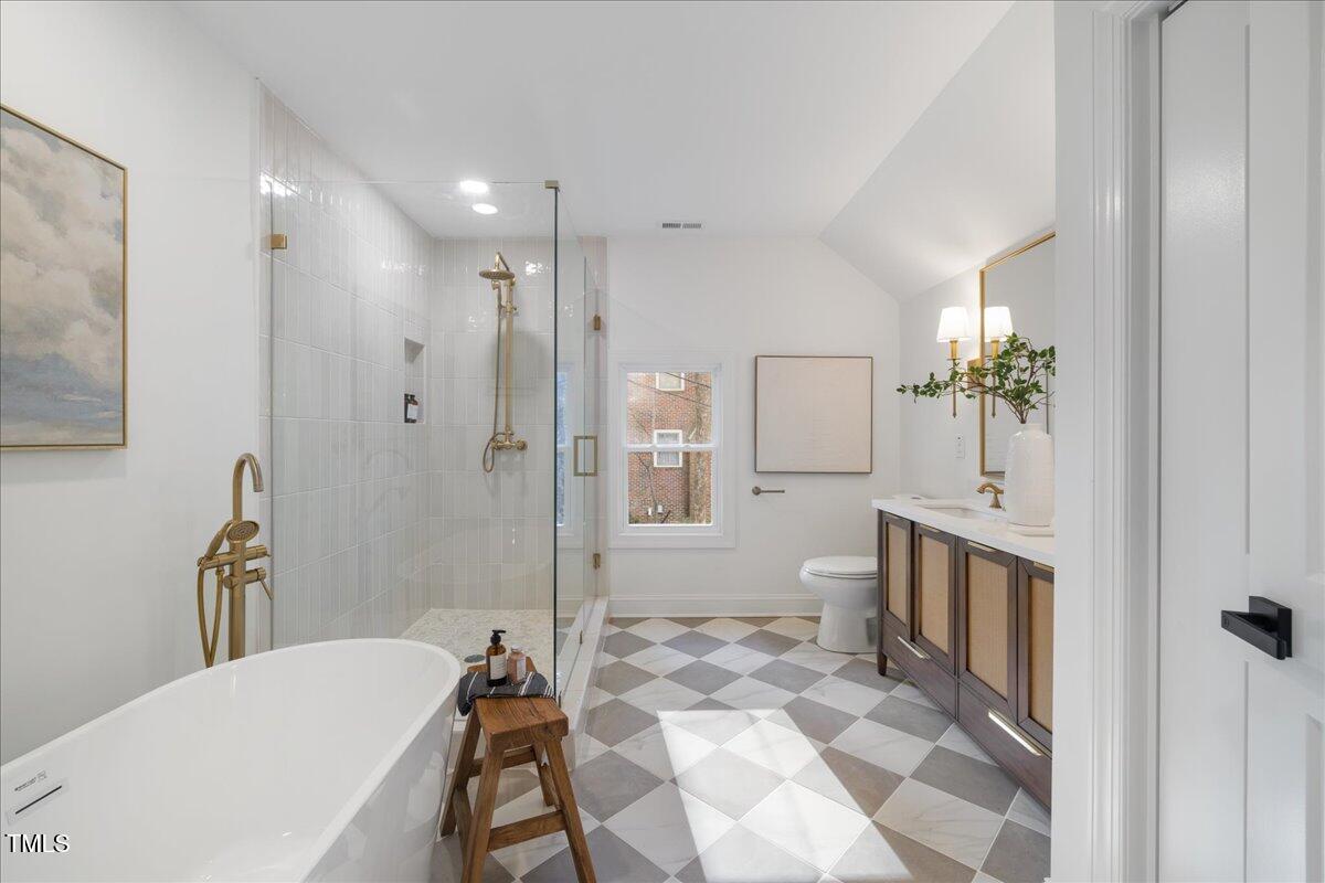 2703 Augusta Drive Durham, NC 27707 - Photo 35 of 45 a spacious bathroom with a double vanity sink a toilet a mirror and shower