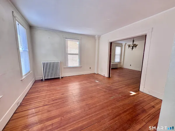 a view of empty room with wooden floor