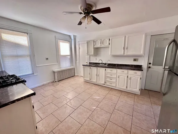 a kitchen with stainless steel appliances a sink a stove a refrigerator and cabinets