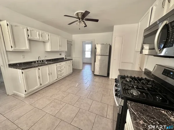 a kitchen with stainless steel appliances a stove a sink and a refrigerator