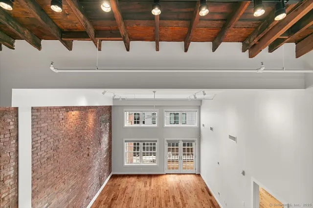a view of a hallway with wooden floor and entryway