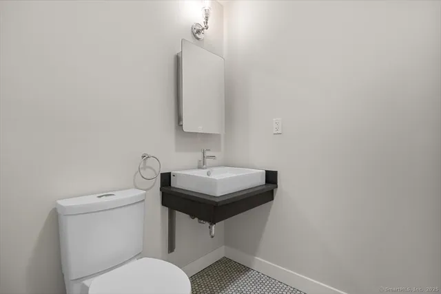 a bathroom with a sink toilet and a mirror