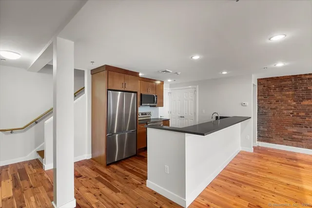 a kitchen with stainless steel appliances granite countertop a refrigerator and a sink
