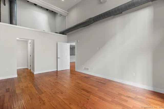 a view of an empty room with wooden floor