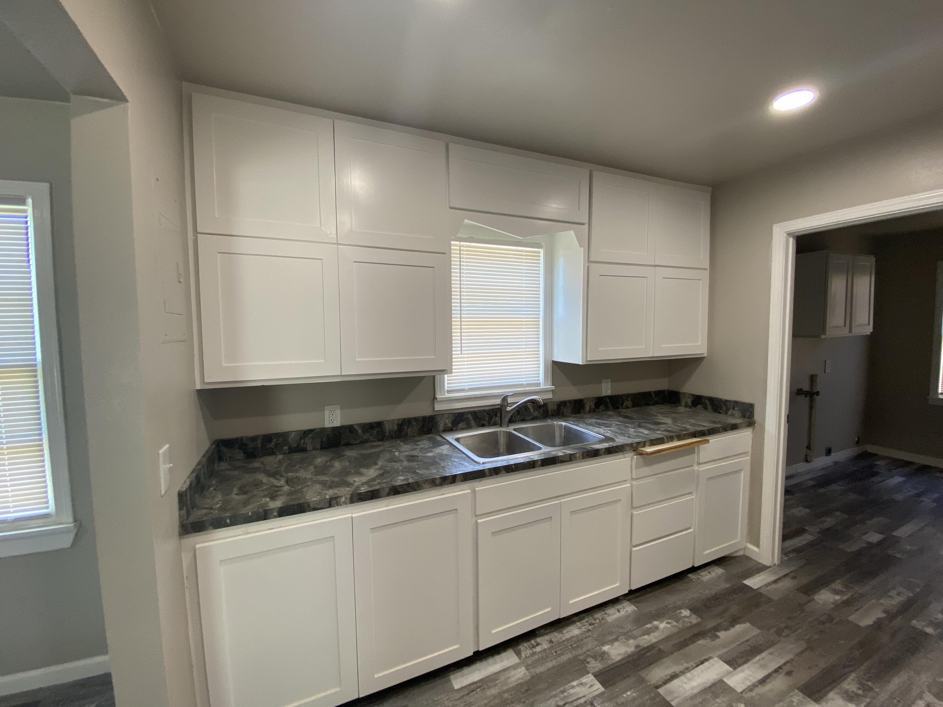 4101 32nd Street Lubbock, TX 79410 - Photo 5 of 13 a kitchen with granite countertop a sink stove and cabinets