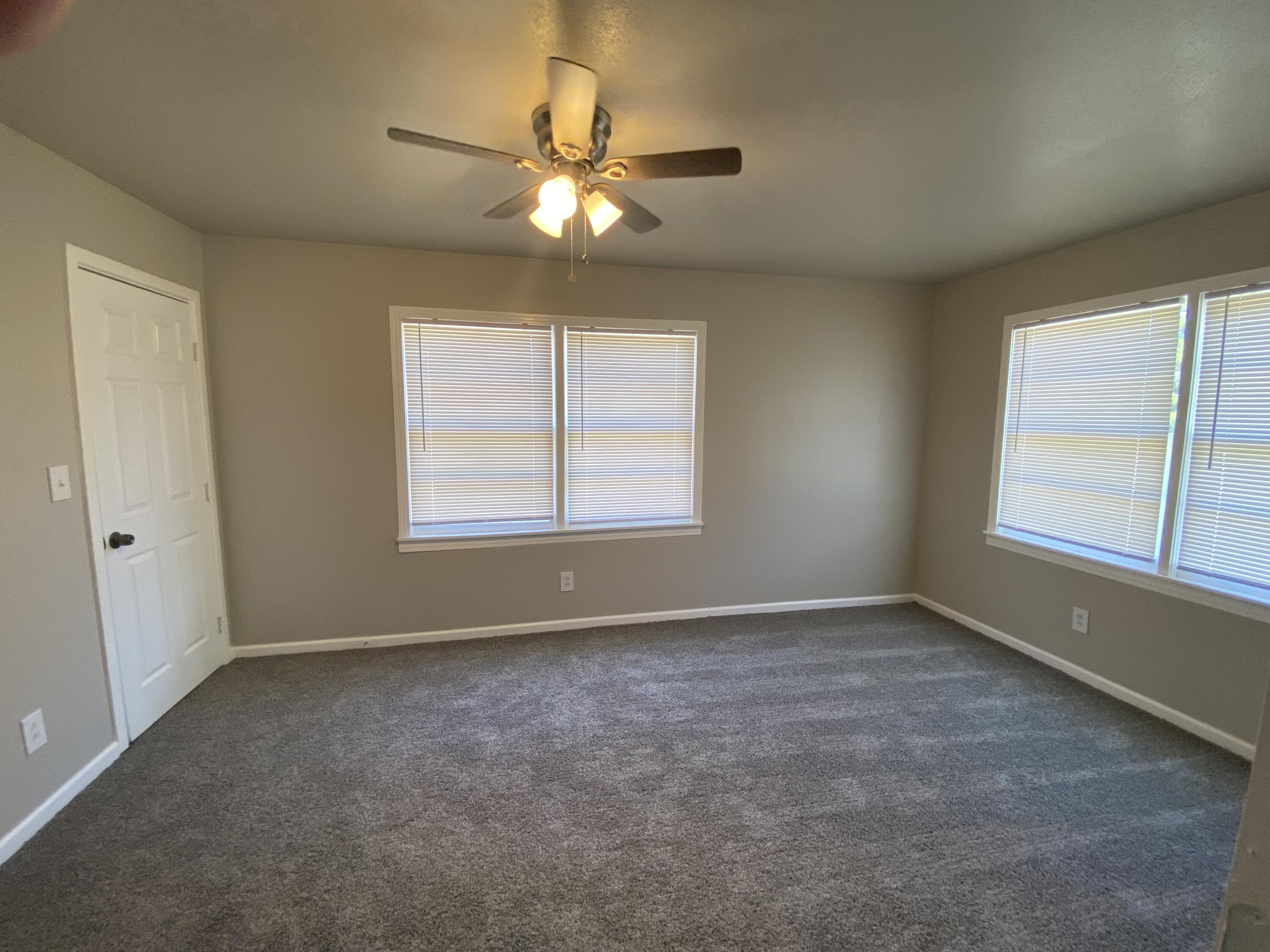 4101 32nd Street Lubbock, TX 79410 - Photo 7 of 13 an empty room with chandelier fan and windows