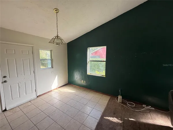 a view of a livingroom with a chandelier fan and windows