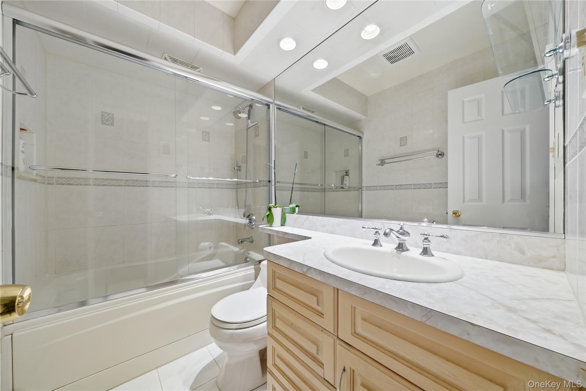 1853 Decatur Avenue Merrick, NY 11566 - Photo 20 of 43 a bathroom with a sink a toilet and bathtub