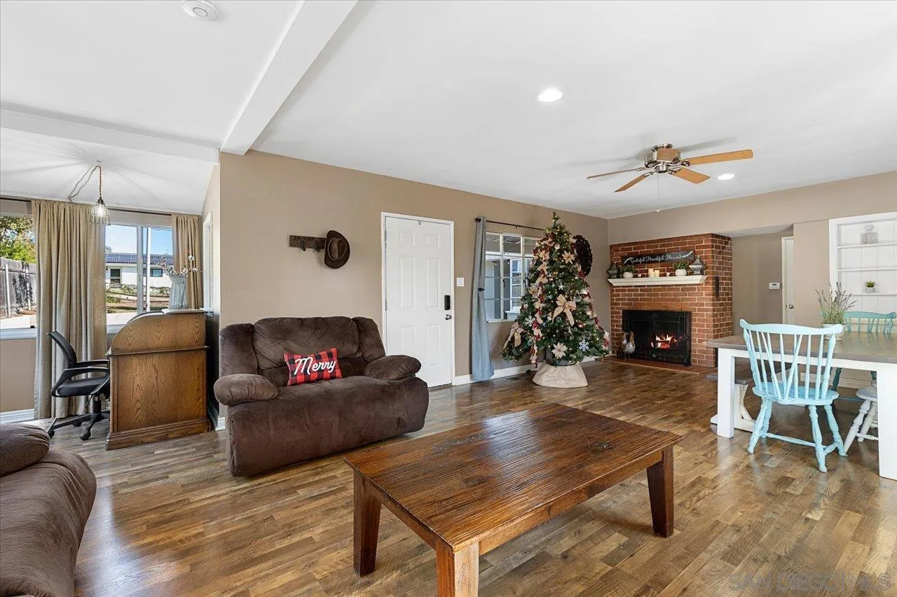 115 Ellis Lane Fallbrook, CA 92028 - Photo 5 of 36 a living room with furniture a fireplace and a flat screen tv