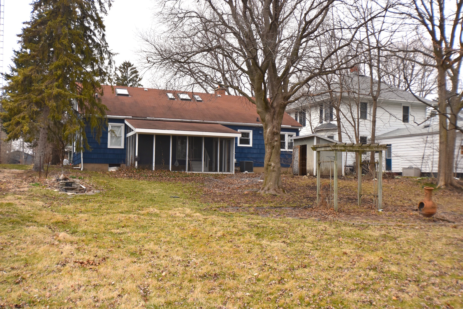 714 Normal Road DeKalb, IL 60115 - Photo 14 of 15 a backyard of a house with large trees and barbeque oven