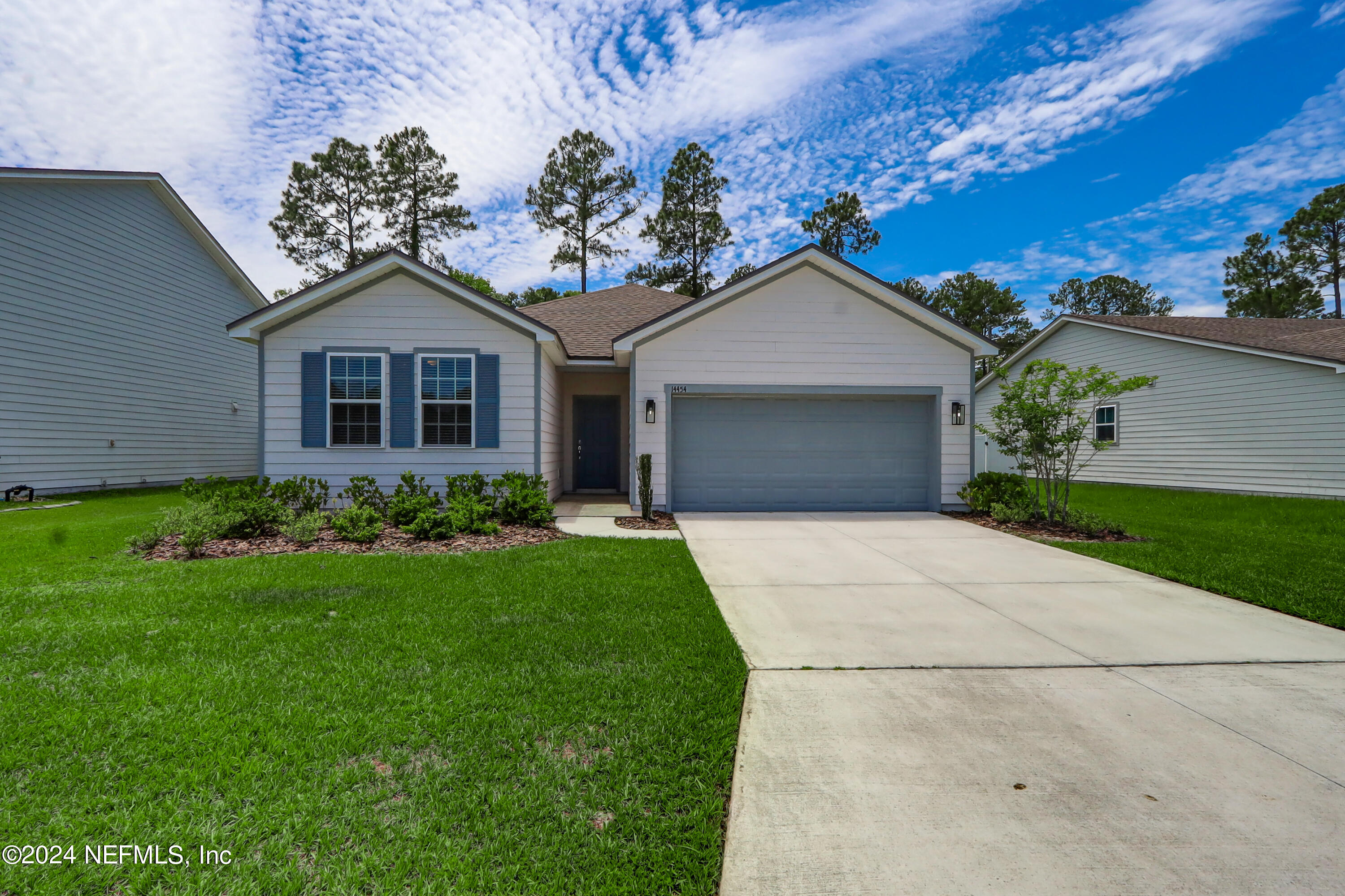 a front view of a house with a garden