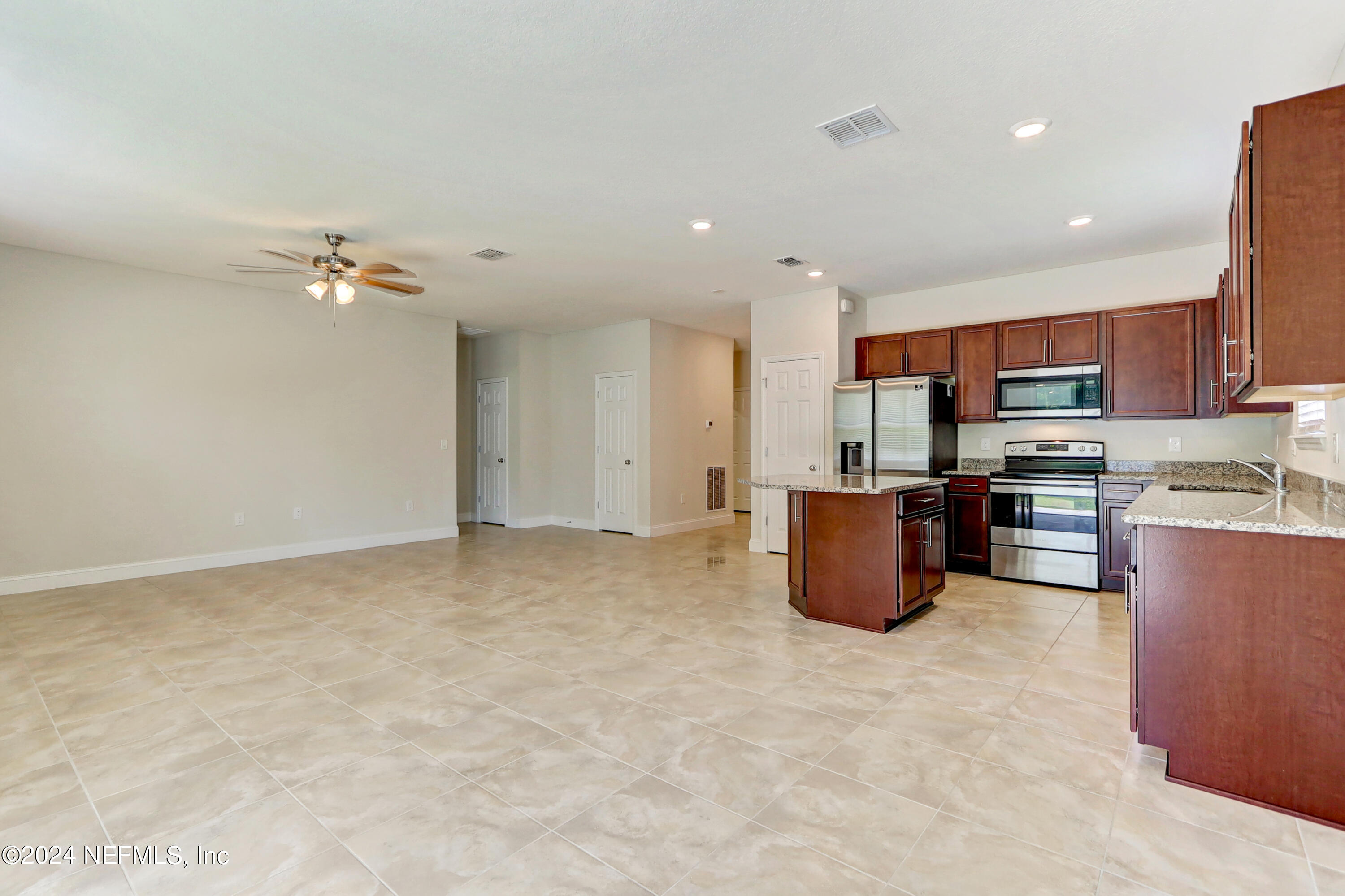 14454 Spring Light Circle Jacksonville, FL 32226 - Photo 13 of 37 a kitchen with kitchen island granite countertop a stove top oven a sink a dining table and chairs