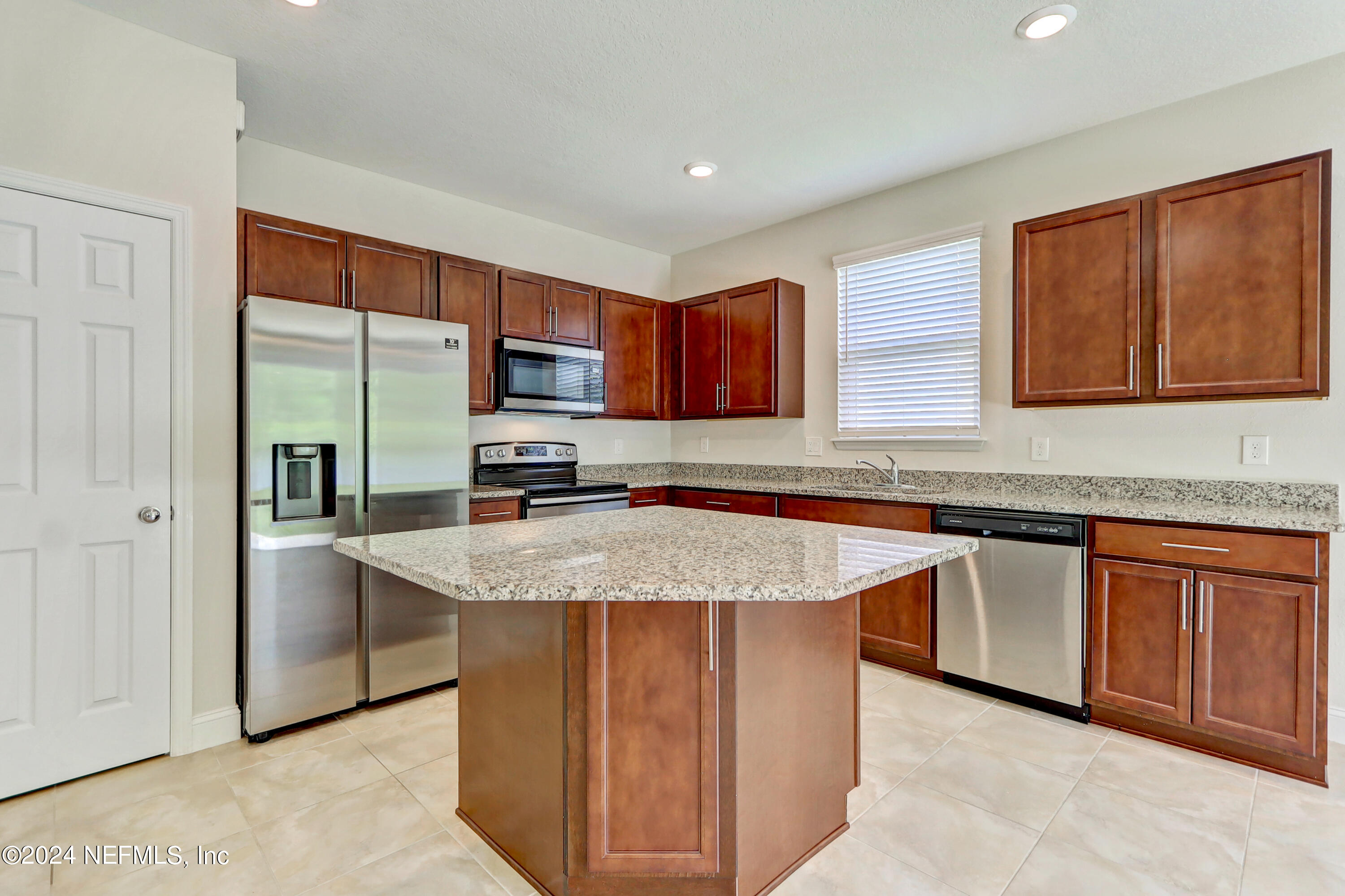 14454 Spring Light Circle Jacksonville, FL 32226 - Photo 16 of 37 a kitchen with stainless steel appliances granite countertop a stove a sink dishwasher and a refrigerator with wooden cabinets