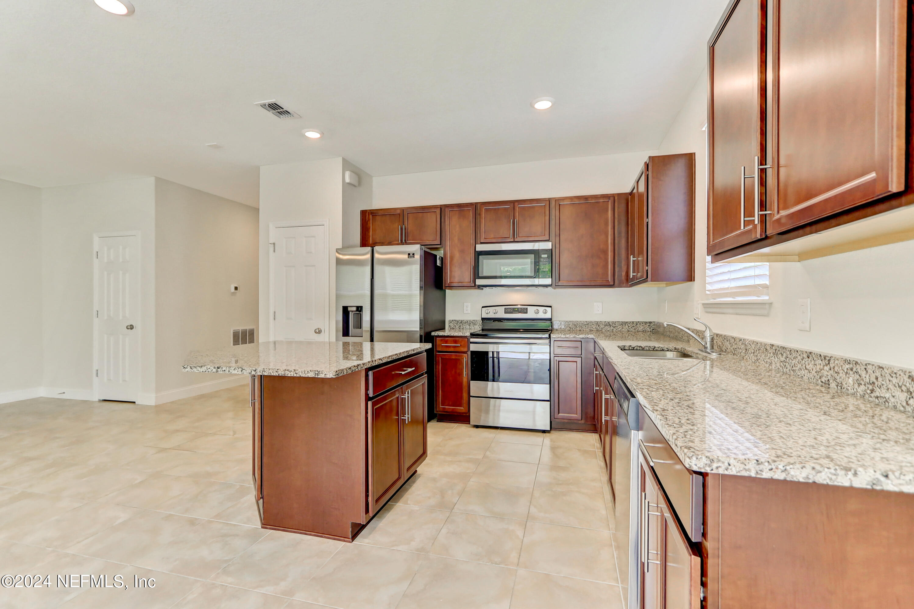 14454 Spring Light Circle Jacksonville, FL 32226 - Photo 18 of 37 a kitchen with stainless steel appliances granite countertop a sink stove and refrigerator