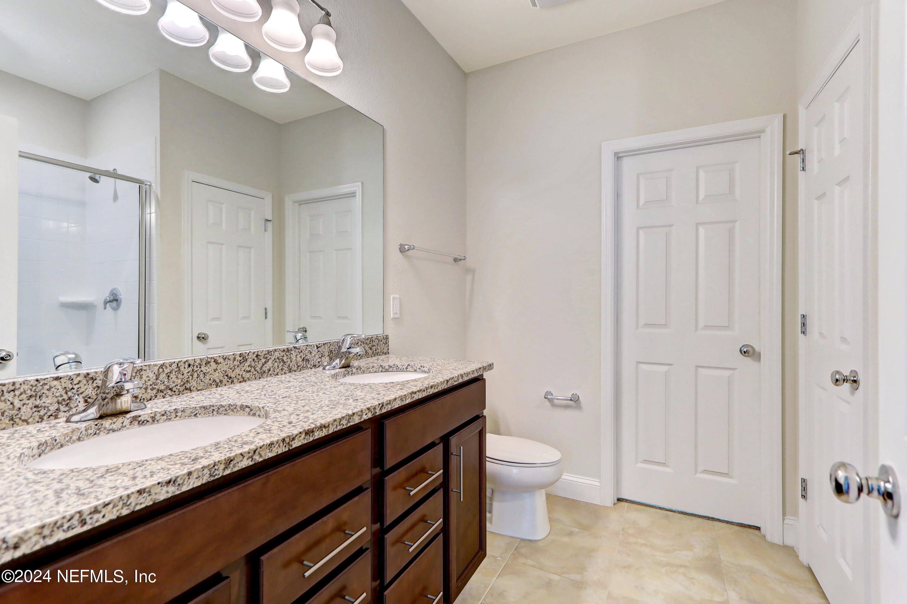 14454 Spring Light Circle Jacksonville, FL 32226 - Photo 26 of 37 a bathroom with a granite countertop sink a toilet and a large mirror