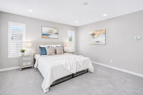 a bedroom with a bed and painting on the wall