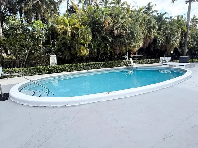 a view of a tennis ground with large tree