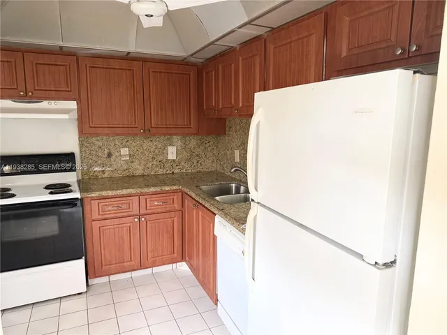 a kitchen with a refrigerator sink and cabinets