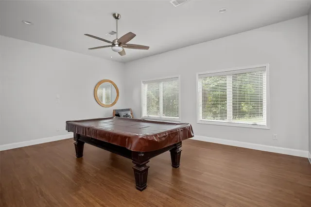 a room with pool table and windows