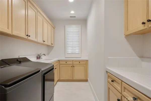 a kitchen with a sink dishwasher and stove with wooden cabinets