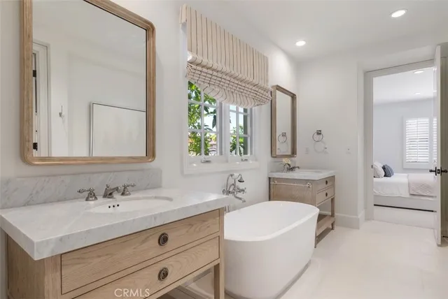 a bathroom with a sink a vanity a mirror and a bathtub