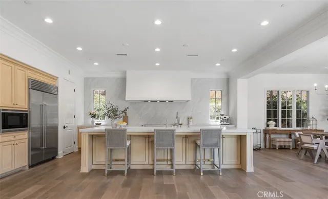 a kitchen with a dining table chairs stainless steel appliances and cabinets
